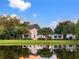 Beautiful home on a pond with lush landscaping, a red front door, and reflective sunset views at 202 Acadia Ter, Kissimmee, FL 34747