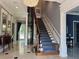 Grand foyer featuring a sweeping staircase, chandelier, and elevator at 202 Acadia Ter, Kissimmee, FL 34747