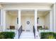 Inviting front porch with decorative columns, potted plants, and a charming white door at 202 Acadia Ter, Kissimmee, FL 34747