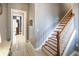 Inviting hallway with staircase and views into other rooms, featuring neutral tones and wood-look tile flooring at 202 Acadia Ter, Kissimmee, FL 34747