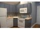 Compact kitchen with gray cabinetry, white appliances, and efficient layout at 202 Acadia Ter, Kissimmee, FL 34747