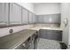 Spacious laundry room with gray cabinets, patterned tile flooring, and modern washer and dryer at 202 Acadia Ter, Kissimmee, FL 34747