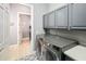 Laundry room with upper cabinets, modern washer and dryer and a patterned tile floor at 202 Acadia Ter, Kissimmee, FL 34747
