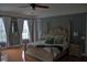 Elegant main bedroom boasts a four-poster bed, hardwood floors, and lots of natural light from large windows at 202 Acadia Ter, Kissimmee, FL 34747