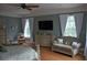This main bedroom offers comfort with a sitting area, flat screen TV, and lots of natural light from large windows at 202 Acadia Ter, Kissimmee, FL 34747