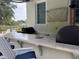 An outdoor kitchen with a pizza oven, granite countertop, grill, and pizza with two glasses of wine at 202 Acadia Ter, Kissimmee, FL 34747