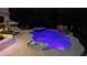 Nighttime view of a luxurious pool area featuring a spa, rock features, underwater lights and lounge seating at 202 Acadia Ter, Kissimmee, FL 34747