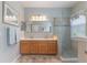 Bright bathroom features double sinks, a large mirror, and walk-in shower with modern fixtures and design at 206 Norfolk Pl, Celebration, FL 34747