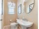 Neat half bathroom showcasing a pedestal sink, decorative mirror, and floral valance at 206 Norfolk Pl, Celebration, FL 34747