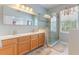 Bright bathroom featuring double sinks, large vanity mirror, and walk-in glass shower, creating a luxurious, functional space at 206 Norfolk Pl, Celebration, FL 34747