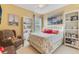 Cozy bedroom featuring a queen-sized bed, a comfortable reading chair, and bright natural light at 206 Norfolk Pl, Celebration, FL 34747