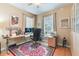 Well-lit bedroom with a red decorative rug, home office and large windows at 206 Norfolk Pl, Celebration, FL 34747