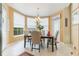 Cozy dining area with large windows, chandelier lighting, and a dark wood table perfect for Gathering meals at 206 Norfolk Pl, Celebration, FL 34747