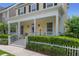 Welcoming front porch with classic white columns, decorative wreath, and lush green hedges at 206 Norfolk Pl, Celebration, FL 34747
