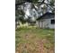 Fenced backyard with a mix of grass and overgrown foliage featuring sliding glass door and an AC unit at 2071 Liston Ct, Orlando, FL 32811