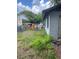 Backyard with overgrown grass, scattered objects, and a view of the neighborhood at 2071 Liston Ct, Orlando, FL 32811