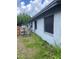 Side exterior view of the house with a grassy yard and barred windows at 2071 Liston Ct, Orlando, FL 32811