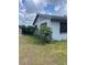 Exterior view of home on a grassy lot with partial shade and overgrown foliage at 2071 Liston Ct, Orlando, FL 32811