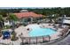 Community pool with lounge chairs and umbrellas, adjacent to a clubhouse and well-manicured landscaping at 219 Rosso Dr, Davenport, FL 33837