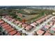 Aerial of homes featuring vibrant, terracotta roofs, lush landscaping, and a serene surrounding at 219 Rosso Dr, Davenport, FL 33837