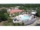 Aerial view of the community clubhouse, pool, and playground amid tropical trees and landscaping at 219 Rosso Dr, Davenport, FL 33837