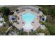 Overhead shot of the uniquely shaped community pool surrounded by pavers, lounge chairs, umbrellas and tropical palms at 219 Rosso Dr, Davenport, FL 33837