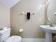 Neutral half bath with modern pedestal sink and fixtures, accented with a dark colored towel and stylish dispenser at 219 Rosso Dr, Davenport, FL 33837