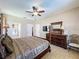 Spacious bedroom featuring a dark four-poster bed, modern TV, a view of the attached bath, and neutral decor at 219 Rosso Dr, Davenport, FL 33837