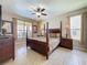 Bedroom with large windows, four-poster bed, ceiling fan, stylish lamps, and neutral decor at 219 Rosso Dr, Davenport, FL 33837