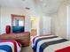 This cozy bedroom features two beds with adjacent bathroom and closet at 219 Rosso Dr, Davenport, FL 33837