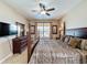 Cozy bedroom featuring a dark four-poster bed, modern TV, large windows, and neutral decor at 219 Rosso Dr, Davenport, FL 33837