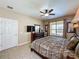 Well-lit bedroom featuring a four-poster bed, modern TV, and neutral decor with a window view at 219 Rosso Dr, Davenport, FL 33837