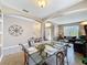 The dining room boasts a glass table, decorative metal accents, and connects to the living room, creating an inviting space at 219 Rosso Dr, Davenport, FL 33837
