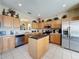 Bright kitchen with an island, stainless steel appliances, and light wood cabinets offering ample storage at 219 Rosso Dr, Davenport, FL 33837
