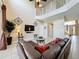 Spacious living room with soaring ceilings, decorative metal accents, and an open view of the staircase at 219 Rosso Dr, Davenport, FL 33837