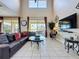 Spacious living room with glass coffee table, high ceilings, and sliding doors to the patio, creating an airy atmosphere at 219 Rosso Dr, Davenport, FL 33837