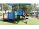 Community playground with green turf, play structure, and bench, surrounded by trees and greenery at 219 Rosso Dr, Davenport, FL 33837