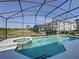 Relaxing screened in pool and spa with a view of the green space and lush landscaping at 219 Rosso Dr, Davenport, FL 33837