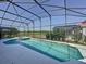 Relaxing pool and spa surrounded by a screened enclosure and lush landscaping at 219 Rosso Dr, Davenport, FL 33837