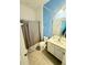 Bathroom with white vanity, shower with curtain, and blue accent wall at 2386 Rama Dr, Kissimmee, FL 34746