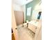 Contemporary bathroom with tiled floor, shower, modern vanity, and light green accent wall at 2386 Rama Dr, Kissimmee, FL 34746