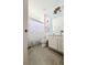 Well-lit bathroom with a Hello Kitty shower curtain, white cabinets, and neutral-toned tile flooring at 2386 Rama Dr, Kissimmee, FL 34746