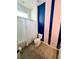 Modern bathroom with shower and stylish blue and pink stripe accent wall at 2386 Rama Dr, Kissimmee, FL 34746