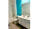 Bright bathroom featuring blue accent wall, with double sink vanity, tub and shower combination, and modern fixtures at 2386 Rama Dr, Kissimmee, FL 34746