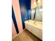 Bathroom featuring blue and pink striped accent wall, single sink vanity, and tiled floor at 2386 Rama Dr, Kissimmee, FL 34746