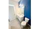 Modern bathroom with blue accent wall, featuring a white vanity, and a coordinated color scheme for a calming experience at 2386 Rama Dr, Kissimmee, FL 34746