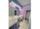 Bathroom with double vanity sinks, ample counter space, and purple accent stripes at 2386 Rama Dr, Kissimmee, FL 34746