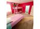 bedroom with pink bunk beds, single bed, a whimsical cartoon wall and carpeted floors at 2386 Rama Dr, Kissimmee, FL 34746