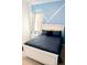 Cozy bedroom with stylish blue wall accents, window with curtain, and a comfortable bed at 2386 Rama Dr, Kissimmee, FL 34746