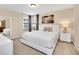 Well lit bedroom featuring a white bed and white furniture, and a black and white seascape picture at 2630 Tranquility Way, Kissimmee, FL 34746